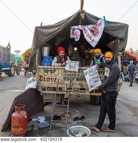 New Delhi, India - December 2020:
Portrait Of A Group Of Farmer Reading News Paper During The Protes