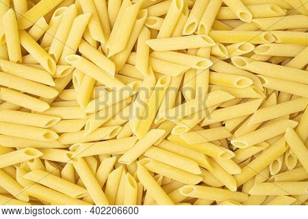 Uncooked Or Dry Penne Lisce Type Of Pasta Texture Background.