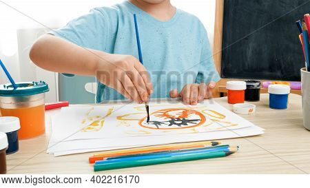 Little Boy Prawing Picture With Colorful Paint On White Paper At Domestic Classroom. Creative Child 