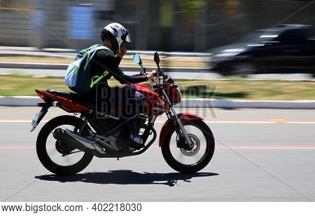 Motorcyclist Is Seen Walking Down The Street