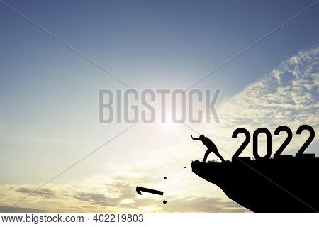 Man Push Number Zero Down The Cliff Where Has The Number 2022 With Blue Sky And Sunrise. It Is Symbo