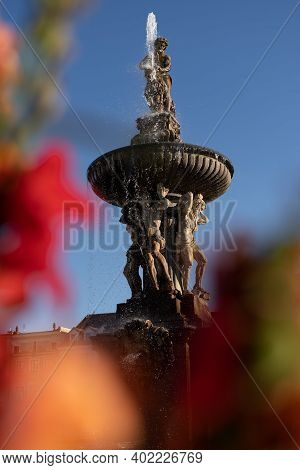 Photo Of Samson Fountain On The Square In Ceske Budejovice Czech Republic Through Red Flowers.