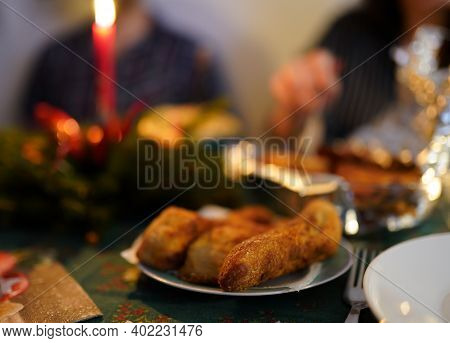 Photo Of Christmas Dinner With Candles, Salad, Blury People And Fish Meat