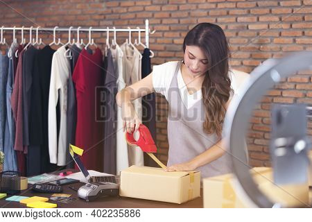 Beautiful Asian Woman Standing Among Several Boxes And Checking Parcels, Working In The House Office