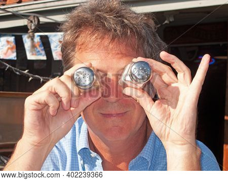 Funny Man Is Joking And Putting Salt Spender As Eyes In Front Of His Eyes