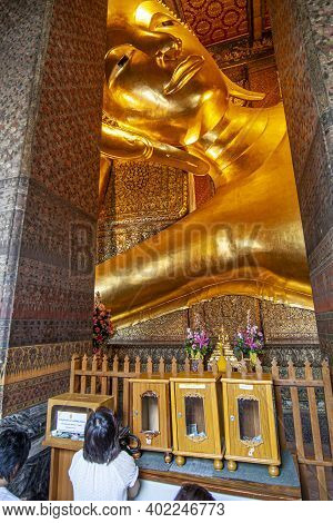 Bangkok, Thailand - January 9, 2008: People Pray To Lying Buddha In Wat Pho, Temple Of First Royal C