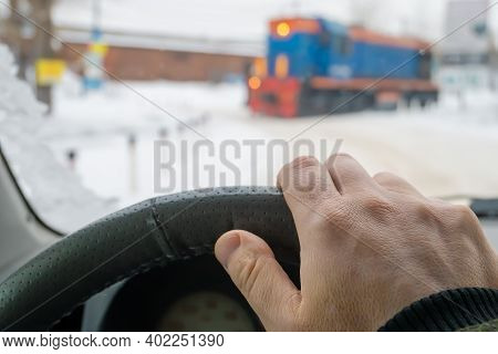 Driver Hand On The Steering Wheel Of A Car That Has Stopped, Waits And Passes The Locomotive Of The 