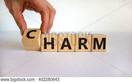 From Harm To Charm. Male Hand Turns The Cube And Changes Word 'harm' To 'charm'. Beautiful White Bac