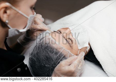Removing Anesthetic Cream From The Eyebrows Before The Permanent Makeup Procedure. Master And Client