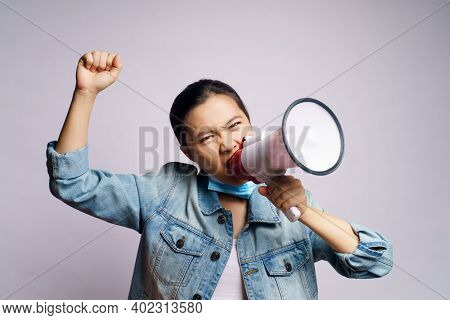 Asian Woman Wearing Protective Face Mask Shouting With Megaphone Isolated Over White Background.