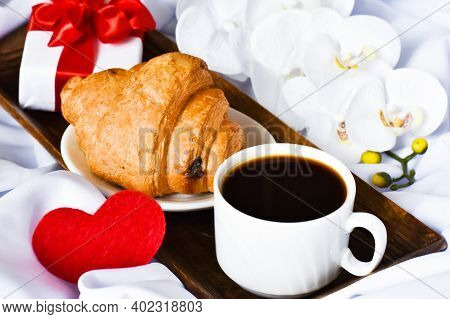 Cup Of Coffee With Gift Box And White Orchid On White Bed. Breakfast On Mothers Day, Valentines Day 