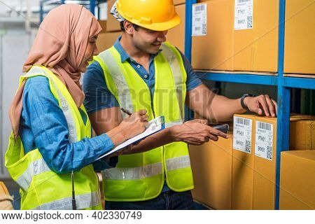 Asian Idian Worker Man With Muslim Worker Woman Working Together By Scanning Bar Code And Qr Code In