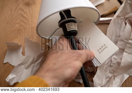 Paris, France - Dec 13, 2020: Pov Male Hand Holding Paper Tag Of A Zara Home Table Elegant Lamp With