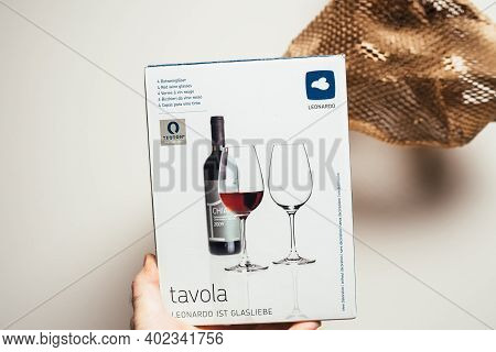 Paris, France - Dec 13, 2020: Pov Male Hand Holding Leonardo Tavola Package Cardboard Box With 4 Red