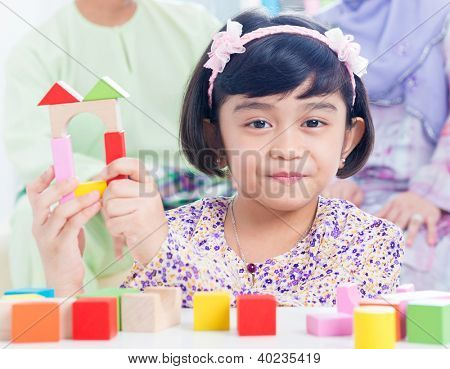 Casa in legno della costruzione bambino musulmano. Sud-est asiatica ragazza gioco woodblock casa a casa.
