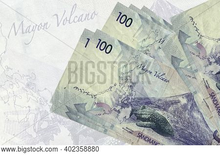 100 Philippine Piso Bills Lies In Stack On Background Of Big Semi-transparent Banknote. Abstract Pre