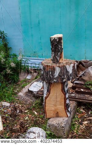 A Log Split In Half With An Ax On A Deck With Male Hands In Cloth Gloves And A Camouflage Jacket In 