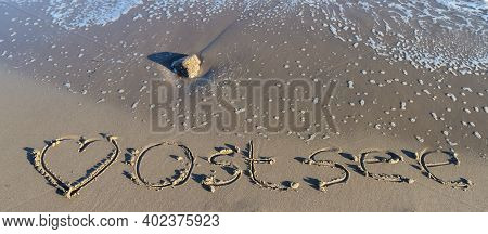 The German Word Ostsee (baltic Sea) And A Heart Written Into The Sand Of The Beach