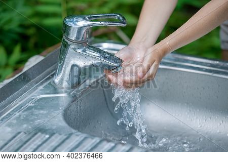 Baby Try To Turn Off Water Faucet But Water Still Leak. A Child's Hand Turning Off The Tap. Save Wat