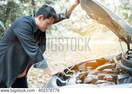 Man Open Car Hood For Repair As Maintenance Service. Man Trying To Repair A Car Engine, Looking Insi