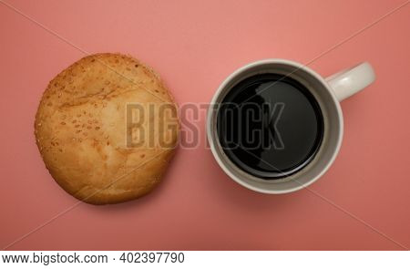 coffe mug with bread humburger bun on pink background
