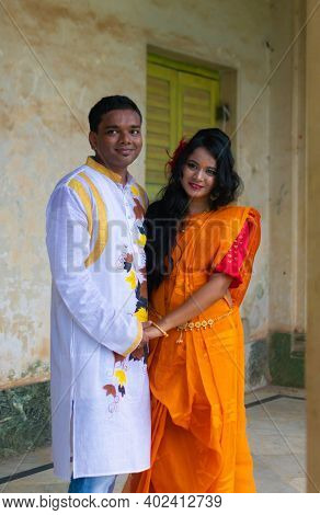 Happy Asian Indian Couple Wearing Colorful Traditional Ethnic Outfits Looking Forward And Smiling. B