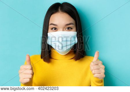 Covid-19, Social Distancing And Pandemic Concept. Close Up Of Young Asian Woman In Medical Mask Show