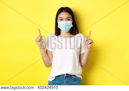 Covid-19, Pandemic And Social Distancing Concept. Young Asian Woman In White T-shirt And Medical Mas