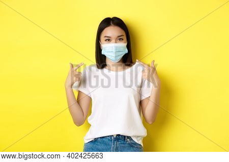 Covid-19, Quarantine And Social Distancing Concept. Young Asian Woman In White T-shirt, Pointing At 