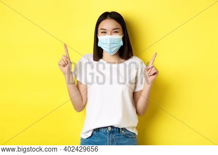 Covid-19, Pandemic And Social Distancing Concept. Young Asian Woman In White T-shirt And Medical Mas