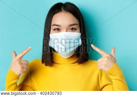 Covid-19, Social Distancing And Pandemic Concept. Close Up Of Young Asian Woman Using Medical Mask D