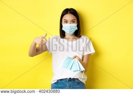Coronavirus, Quarantine And Medicine Concept. Young Asian Woman Pointing Finger At Medical Masks For