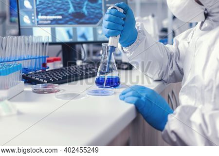 Doctor Working To Find A Cure For Coronavirus Using Micropipette And Petri Dish Wearing Protective S