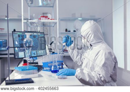Engineer In Microbiology Lab Holding Micropipette With Sample From Test Tube. Chemist In Modern Labo