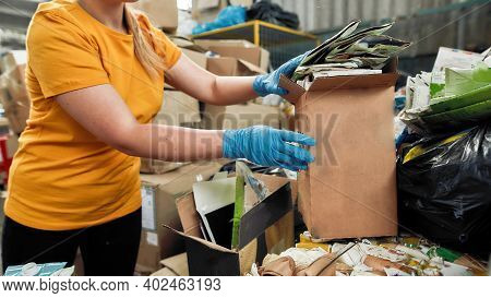 Tetra Pack Waste Paper Packed For Reuse Held By Young Woman On Rubbish Disposal Station, Widescreen.