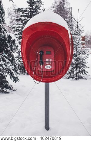 A Red Old Pay Phone In A Winter Park After A Heavy Snow Fall. Vertical Photo, Front View.