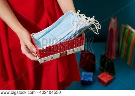 Female Hands Holding Red Gift Box Full Of Medical Masks.