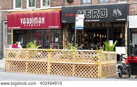 Astoria, New York, Usa - 30 July 2020: People Eating At Tables Placed In City Street Surrounded By W