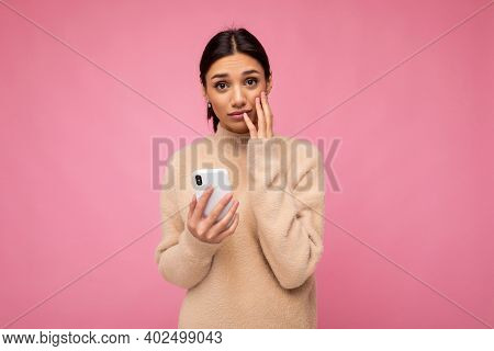 Attractive Cute Young Upset Sad Brunet Woman Wearing Beige Warm Sweater Standing Isolated Over Pink 