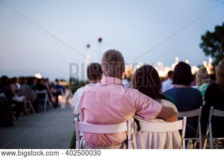 People Are Watching A Concert Of Classical Music. Blurred Young And Adult Women And Men And Other Pe
