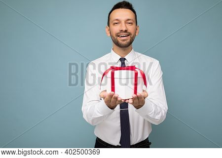 Photo Shot Of Handsome Positive Brunette Unshaven Young Man Isolated Over Blue Background Wall Weari