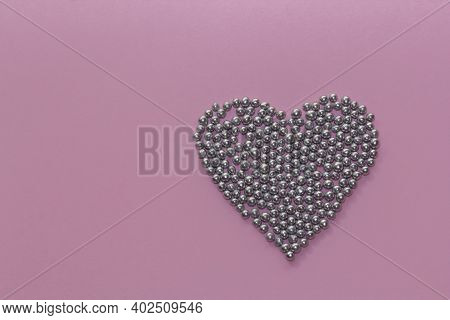 Silver Pearl Sprinkles Arranged In A Heart Shape On A Pink Rustic Background. Valentines Day, Greeti