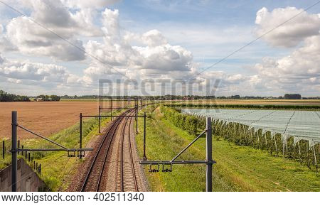 Curved Double Track Train Rails With Gantries With Electric Catenaries In A Dutch Agricultural Lands