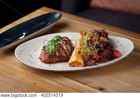 Pork Neck With Chickpea Roll And Salad Mix. Restaurant Main Course With Well Done Meat, Veal Or Beef