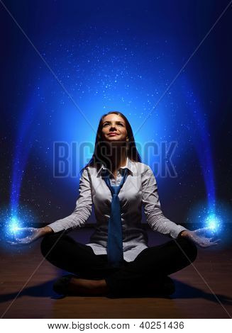 Mladý obchodní žena sedí v asana lotus a meditací
