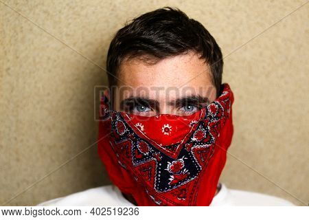 Close-up Portrait Of Young Caucasian Brown-haired Man In Red Bandana On Face At Home Looking At Came