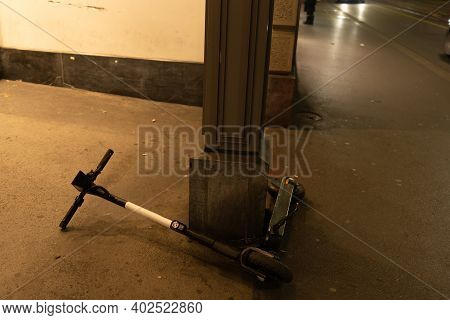 Electric Scooter Lying Down On Sidewalk In Dark Evening. Problem Of Share System Rules. Zurich, 19. 