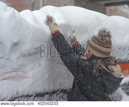 The Picture Shows A Side View Of A Little Girl With Her Arms Raised Picking Up Snow With Her Hands S