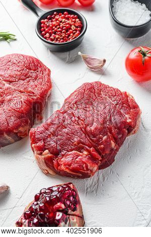 Raw Rumpsteak, Farm Beef Meat With Seasonings, Rosemary, Garlic, Garnet. White Textured Background. 