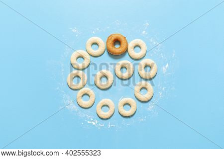 Preparing Doughnuts At Home, Raw Dough In A Ring Shape And One Fried Donut, On Blue Background. Top 